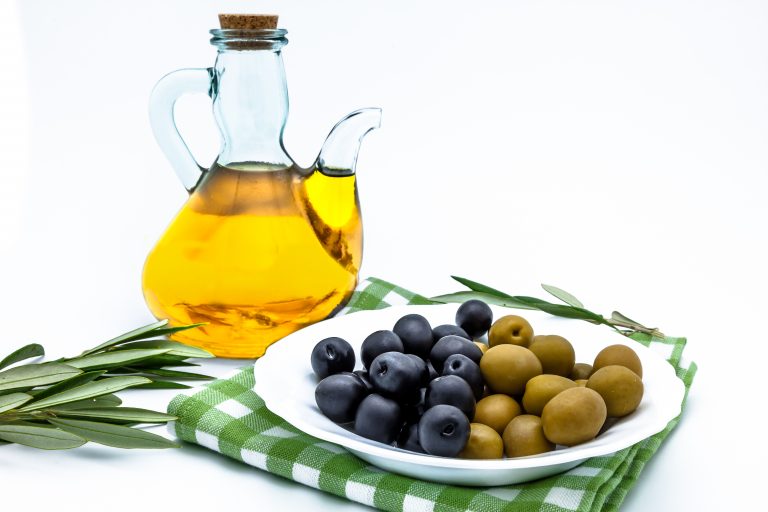 Olives,  olive oil and olives leaves on a white background